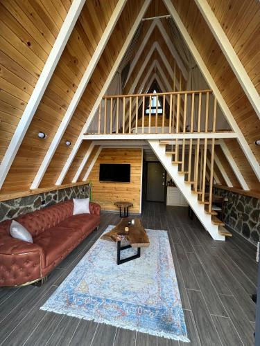 a living room with a couch and a staircase at Ruby Rize Bungalov in Pazar