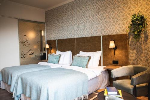 a hotel room with a large bed and a chair at Home Hotel Havnekontoret in Bergen