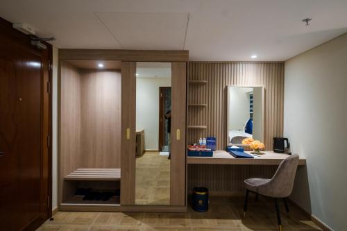a room with a desk with a chair and a mirror at Sandals Mimosa in Da Lat