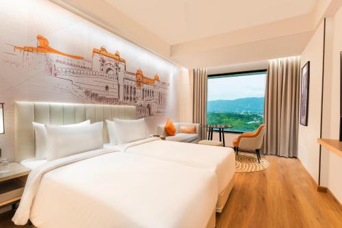 a bedroom with a large white bed and a large window at Sarovar Premiere Alwar in Alwar