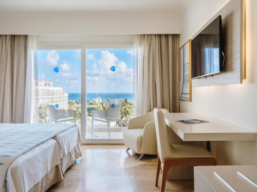a hotel room with a bed and a view of the ocean at Grupotel Gran Vista & Spa in Can Picafort