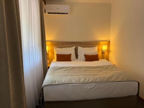 ein Schlafzimmer mit einem großen Bett und zwei Kissen in der Unterkunft Hotel Kopaonik Lukovska Banja in Lukovo
