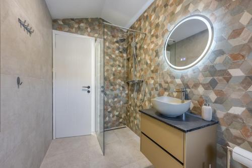 ein Badezimmer mit Waschbecken und Spiegel in der Unterkunft Villa Elisadora in Poreč