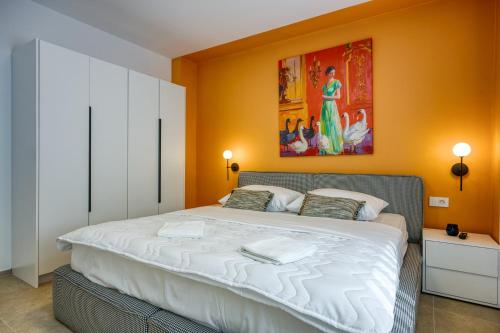 ein Schlafzimmer mit einem Bett und einem Gemälde an der Wand in der Unterkunft Villa Elisadora in Poreč