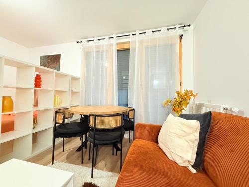 a living room with a couch and a table at Vases d'honneur HOME proche de Paris et du stade de France in Aubervilliers