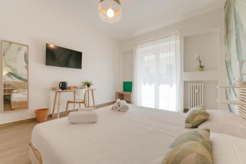 a white bedroom with a large bed and a window at Smart Arena Rooms - 10 minuti dall'Arena in Verona