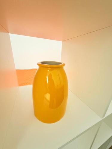 a yellow vase sitting on a shelf in a room at Vases d'honneur HOME proche de Paris et du stade de France in Aubervilliers