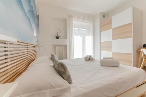 a large white bed in a white room with a window at Smart Arena Rooms - 10 minuti dall'Arena in Verona