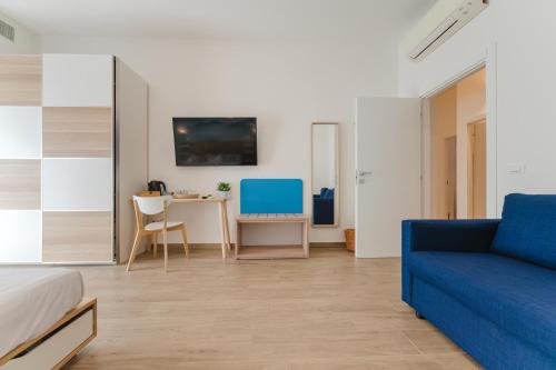 a bedroom with a blue couch and a table at Smart Arena Rooms - 10 minuti dall'Arena in Verona