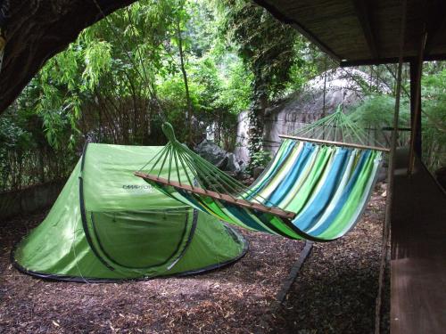 two hammocks hanging from a tent in a yard at Shantee House in Budapest