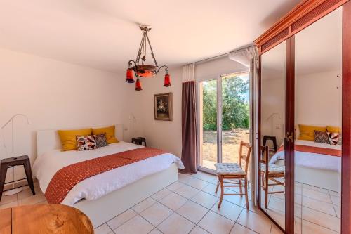 a bedroom with a bed and a large window at La Gloriette d'Oustaou - au coeur du Verdon in Régusse
