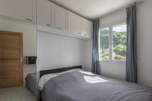 a bedroom with a bed and a window at Morgon Garden Lodge - Proche de la Rivière in Savines