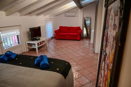 a room with a bed and a red couch at A Casa di Paola in Sirmione