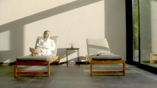 a woman sitting in a chair with a baby in it at Marienkron - Retreat & Health Resort in Mönchhof