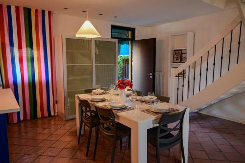 a dining room with a white table and chairs at A Casa di Paola in Sirmione