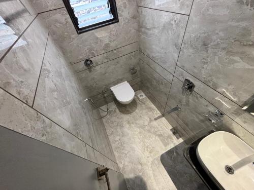 a bathroom with a toilet and a sink at Iconic Hotel in Ahmedabad