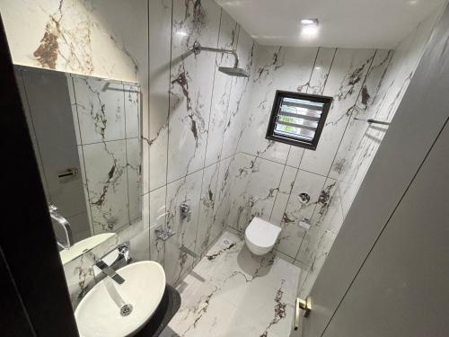 a bathroom with a toilet and a sink at Iconic Hotel in Ahmedabad