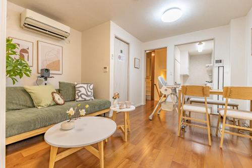 a living room with a green couch and a table at Asakusa Cozy Japanese House with Tatami & Projector, 5min to Station in Tokyo