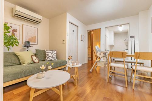 a living room with a green couch and a table at Asakusa Cozy Japanese House with Tatami & Projector, 5min to Station in Tokyo