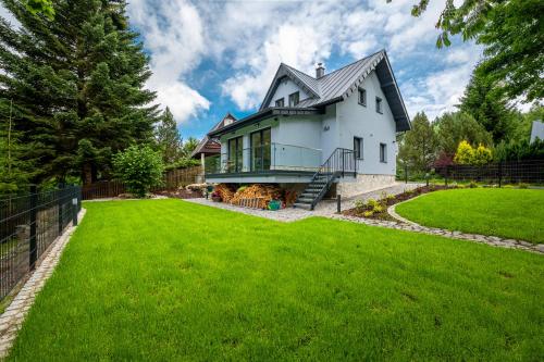 a house with a green lawn in front of it at Chata u Tichého Lesa Pernink in Pernink
