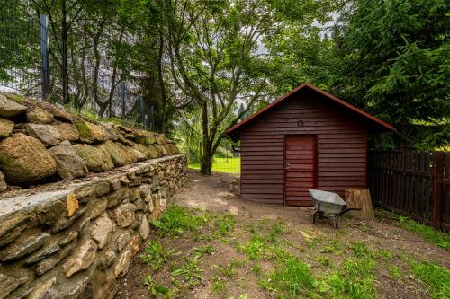 a small shed next to a stone wall at Chata u Tichého Lesa Pernink in Pernink