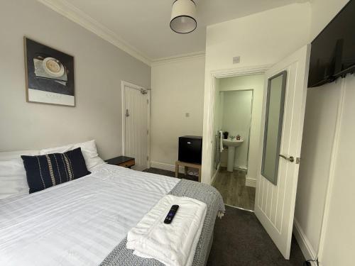 a bedroom with a white bed and a sink at Charles Street House in Redcar