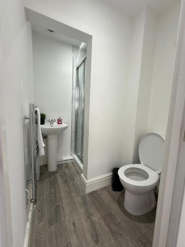 a white bathroom with a toilet and a sink at Charles Street House in Redcar