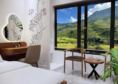 a bedroom with a bed and a desk and a window at Boutique En Hotel Sapa in Sa Pa