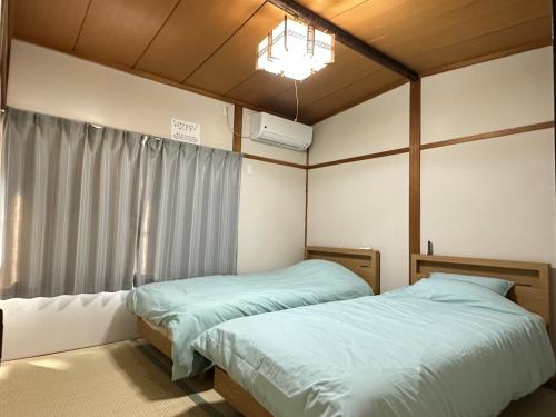 a bedroom with two beds and a window at Y K Kyoto Nijo Traditional House close to Arashiyama in Kyoto