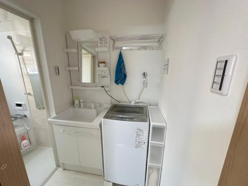 a small kitchen with a sink and a refrigerator at Y K Kyoto Nijo Traditional House close to Arashiyama in Kyoto