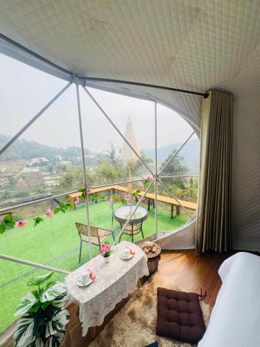 a room with a table and a large window at Mon phuree Glamping in Ban Tai
