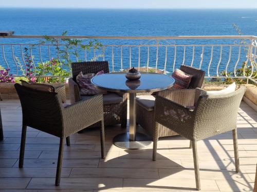 a patio with a table and chairs and the ocean at Villa Rubis-vue mer à couper le souflle in Saint-Raphaël