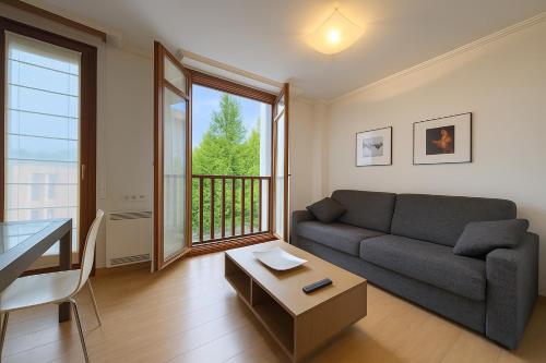 a living room with a couch and a table at Talaimendi Apartamentuak Zarautz in Zarautz