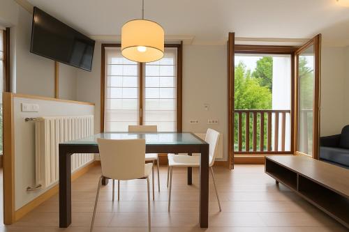 a dining room with a black table and chairs at Talaimendi Apartamentuak Zarautz in Zarautz