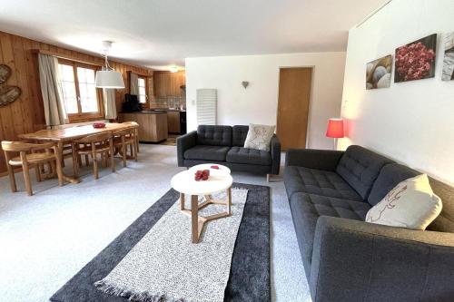 a living room with a couch and a table at Chalet Woodland - Ferienwohnung mit Terrasse in Ritzingen
