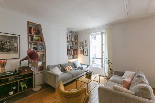 un salon avec deux canapés et une fenêtre dans l'établissement Spacious apartment near the Villette, à Paris
