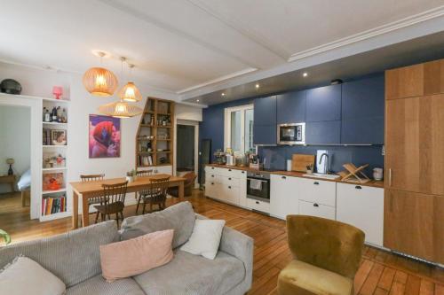 un salon avec un canapé et une salle à manger dans l'établissement Spacious apartment near the Villette, à Paris