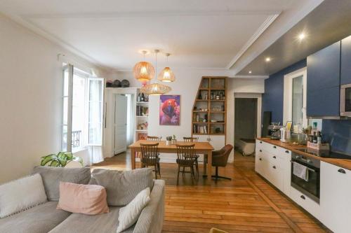 un salon et une cuisine avec un canapé et une table dans l'établissement Spacious apartment near the Villette, à Paris