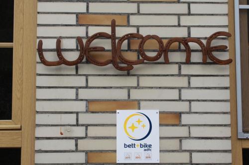 a sign that says belt blue hanging on a brick wall at Hotel Panorama in Wees