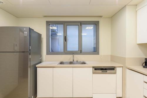 a kitchen with a sink and a refrigerator at Solidere Lavish Apartments in Downtown Beirut in Beirut