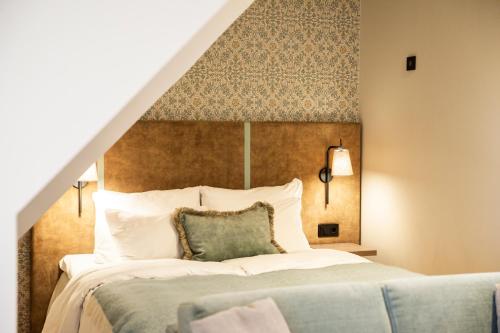 a bedroom with a large bed with a large headboard at Home Hotel Havnekontoret in Bergen
