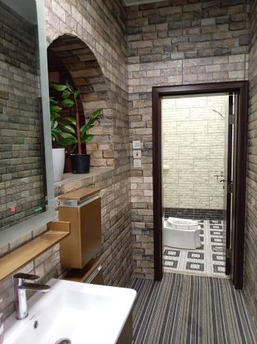 ein Badezimmer mit Waschbecken, Spiegel und Toilette in der Unterkunft فيلا وشاليه نسيم لافا in Rayyis