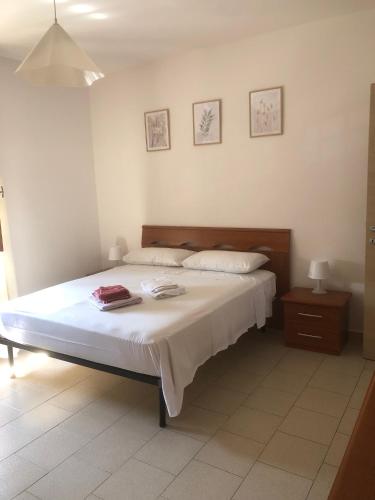 a bedroom with a large bed with white sheets at Civico 82 in Hermada