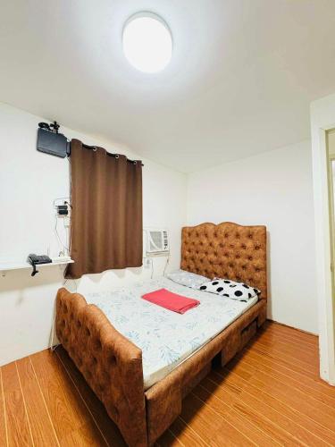 a bedroom with a large bed with a brown headboard at Camella Homes near Airport 2 bedrooms in Davao City
