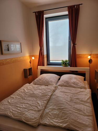 Un dormitorio con una cama grande y una ventana. en Inseloase, en Fehmarn