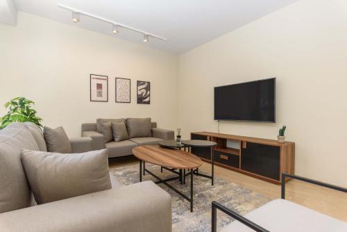 a living room with a couch and a flat screen tv at Solidere Lavish Apartments in Downtown Beirut in Beirut
