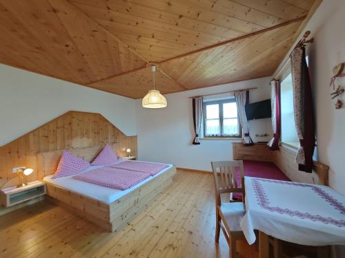 a bedroom with a bed and a table and chairs at Großberghof in Taxenbach