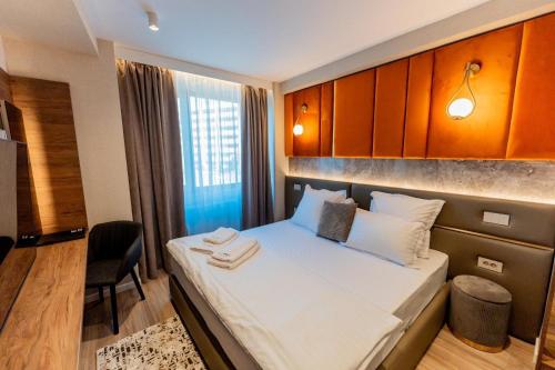 a small room with a bed and a chair at Villa Bijoux in Ploieşti