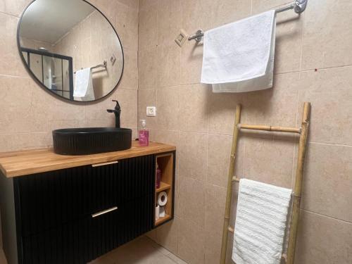 a bathroom with a sink and a mirror and towels at בית הקונגרס גבעת אולגה in H̱adera