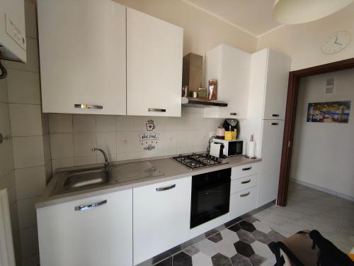 a kitchen with white cabinets and a sink at Hyria Intero Appartamento in centro città in Avellino